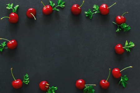 Fresh cherries on black granite table, isolated background in top view flat lay with copy space for...