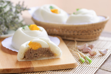 Chinese white steamed bun known as Dim Sum or salapao filled with minced pork seasoning decorate...