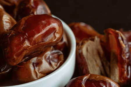 Khalas date palm on black granite table in close up with copy space for background or wallpaper. Dates fruit is food for Ramadan or medjool. Delicious dried fruit with sweet taste and have high fiberの写真素材