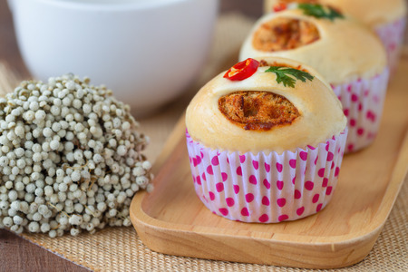 Homemade soft and sticky bun filled with dried shredded pork or pork floss and shrimp roasted chili paste on wood plate. Thai style delicious bread for snack or appetizer with sweet and spicy taste.の写真素材