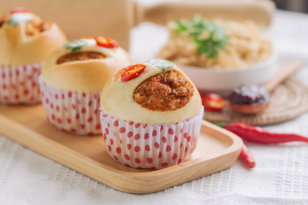 Homemade cup of soft and sticky bun with dried shredded pork or pork floss and shrimp roasted chili paste on wood table with ingredients. Thai style delicious bread with sweet and spicy taste.の写真素材