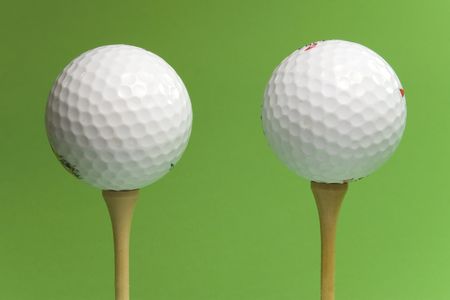 two golf balls on green backgroundの写真素材