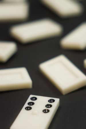 white domino game fall down over black backgroundの写真素材
