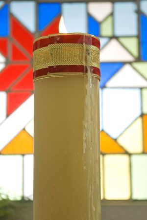 one bright wax candle in color church のeditorial素材