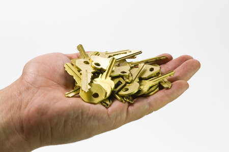one human hand with gold keys  isolated の写真素材