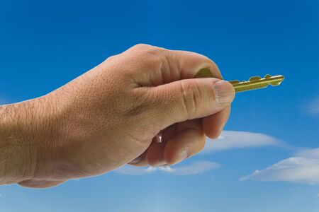 one human hand with gold keys  on sky の写真素材