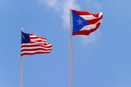 usa and puerto rico flags on blue skyの写真素材