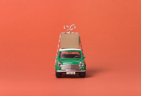 Green travel toy car side on orangeの写真素材
