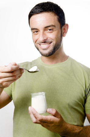 Happy Young Man with Beard Eating Yogurt Isolated on White Backgroundの写真素材