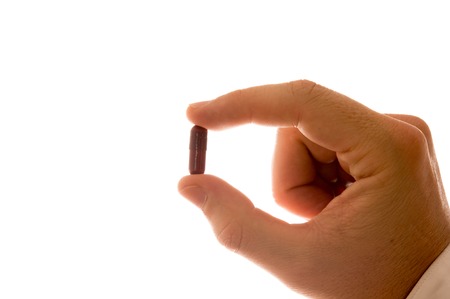 Male Hand with Pill isolated in Whiteの写真素材