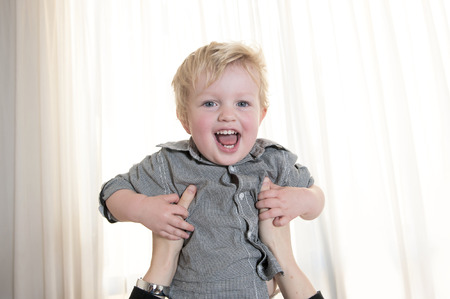 Mother hands lift up smiling sweet little son の写真素材