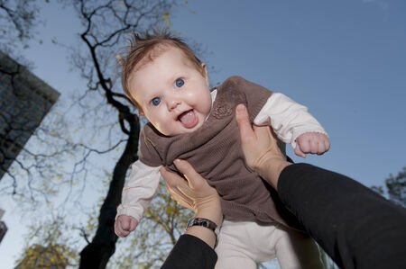 Young mother playing with sweet baby girl outdoors