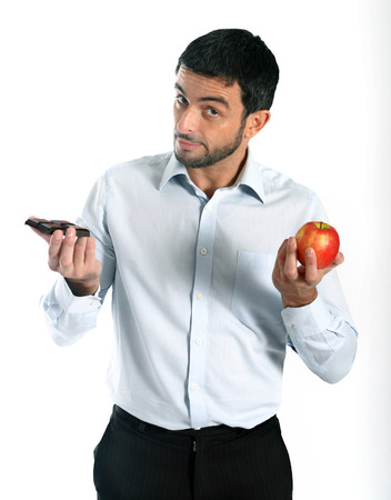 Attractive man holding Chocolate and Apple as a diet choiceの写真素材