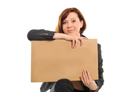 happy successful red hair business woman wearing a suit holding blank cardboard billboard on white background の写真素材