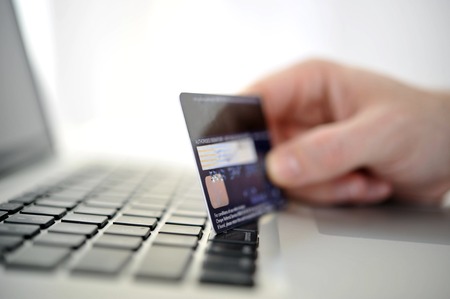 Man holding credit card in hand online shopping and banking with computerの写真素材