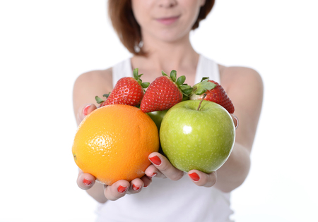 young woman carrying mix of fruit in both handsの写真素材