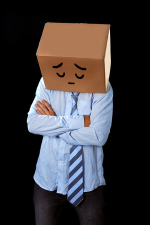 messy business man with folded arms and cardboard box on head with a sad cartoon expression draw wearing loose tie and shirt isolated on black background in depression, problems at work and financial crisis conceptの写真素材