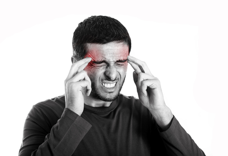 Young attractive Man with Beard suffering Headache and migraine in pain and ache face expression Isolated on White Background touching his head with red color on ache areaの写真素材