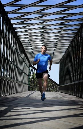 young athletic man practicing running and crossing urban city bridge  in fitness , body care, sport...