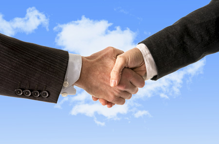 close up of a business man shaking hands with a business woman isolated on blue sky backgroundの写真素材