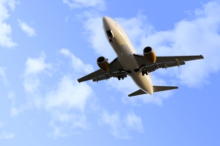 commercial flight of airplane close up view flying on blue sky with clouds during  take off...