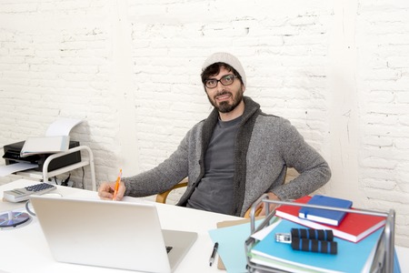 young hispanic attractive and happy hipster 30s businessman working at modern home office with computer laptop dressing casual in creative freelancer business success conceptの写真素材