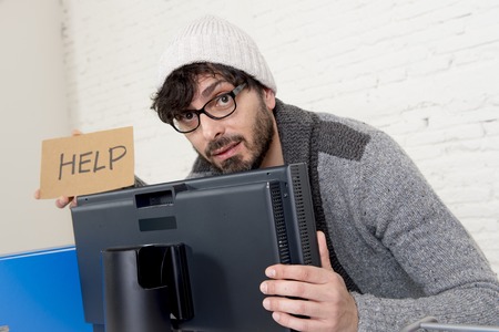 young worried businessman in cool hipster beanie look holding help sign working in stress at home...