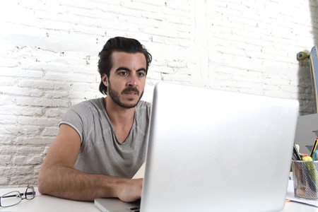 young modern hipster style student or businessman working with laptop computer at home office in creative freelance business success conceptの写真素材
