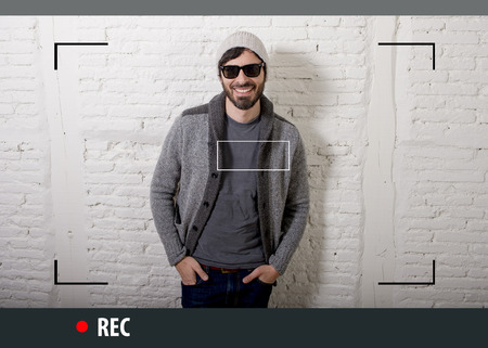 young attractive vlog hipster and trendy style looking man smiling happy  talking to camera posing...