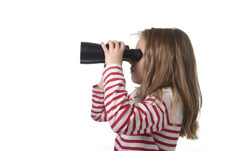 blond hair young little girl looking holding binoculars looking through observing and watching curious isolated on white backgroundの写真素材