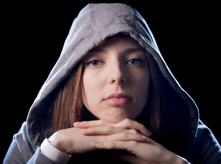 close up portrait of cool teenager girl or young woman on her 20s posing cool showing attitude wearing hood on isolated on white background in modern hipster style looking defiantの写真素材