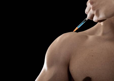 young body building sportsman using steroids for increasing sport and athletic  performance injecting syringe in shoulder in sport cheat doping and illegal use of hormonesの写真素材