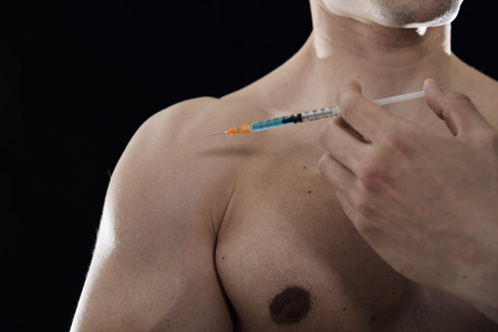 young body building sportsman using steroids for increasing sport and athletic  performance injecting syringe in shoulder in sport cheat doping and illegal use of hormonesの写真素材