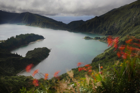 long exposure landscape view of crater volcano lake or lagoon in Sao Miguel island Azores in Portugal with wind blurred flowers and beautiful turquoise color water in holiday travel destinations conceptの写真素材