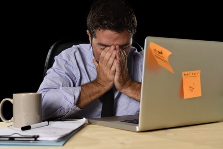 young attractive tired businessman in shirt and tie tired and overwhelmed by heavy work load...
