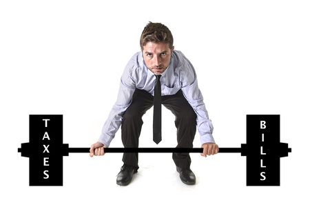 corporate composite of young attractive businessman power lifting heavy weights metaphor to cost of living , obligations , taxes and bills in burden and struggle concept isolated on white backgroundの写真素材