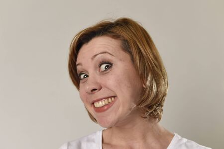 young attractive and beautiful red hair woman smiling happy and cheerful in friendly joyful face expression gesturing and having fun isolated on grey background in happiness emotion conceptの写真素材