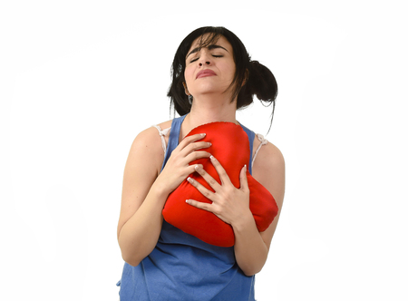 young attractive and beautiful woman hurt and suffering for lost love holding red heart shape pillow...
