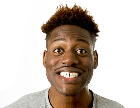 young friendly and happy afro american man smiling excited and posing cool and cheerful isolated on white background having fun looking positive in intense happiness facial expressionの写真素材