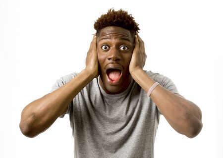 close up portrait of young attractive afro american man surprised with opened mouth and wide open eyes in disbelief amazed wow face expression isolated on white backgroundの写真素材
