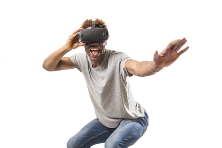 young happy and excited afro american man wearing virtual reality vr 360 vision goggles enjoying video game isolated on white background in innovation and gaming technology conceptの写真素材
