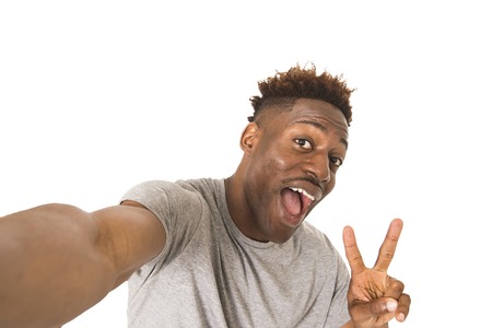 young afro american man smiling happy taking selfie self portrait picture with mobile phone looking...
