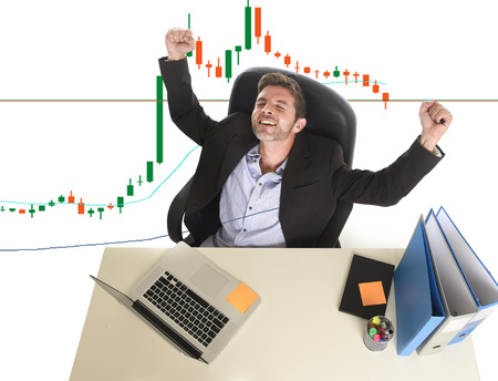 young attractive businessman crazy happy after winning forex or stocks trade  sitting at office...