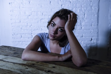 young beautiful sad and depressed woman looking wasted and frustrated suffering pain and depression feeling low and break down lonely and thoughtful at home in sadness emotion conceptの写真素材
