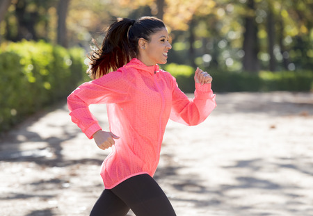 young attractive and happy runner woman in Autumn sportswear running and training on jogging...
