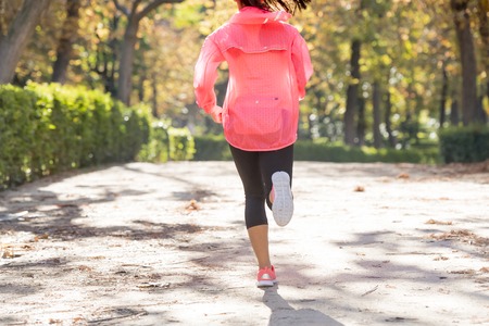 young attractive and happy runner woman in Autumn sportswear running and training on jogging...