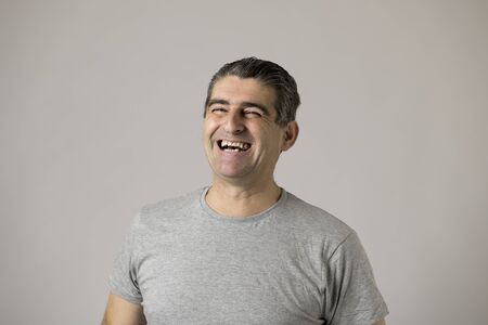 portrait of mature white man 40 to 50 years old smiling and laughing happy and excited showing nice and positive face expression isolated on grey background in feelings and emotions conceptの写真素材