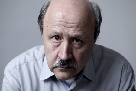 head portrait of senior mature old man on his 60s looking sad and worried suffering pain and...
