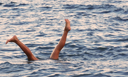 Feet sticking out of the sea at sunset