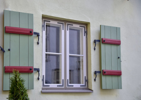 Old window with wooden frames on the white wall of the houseの写真素材